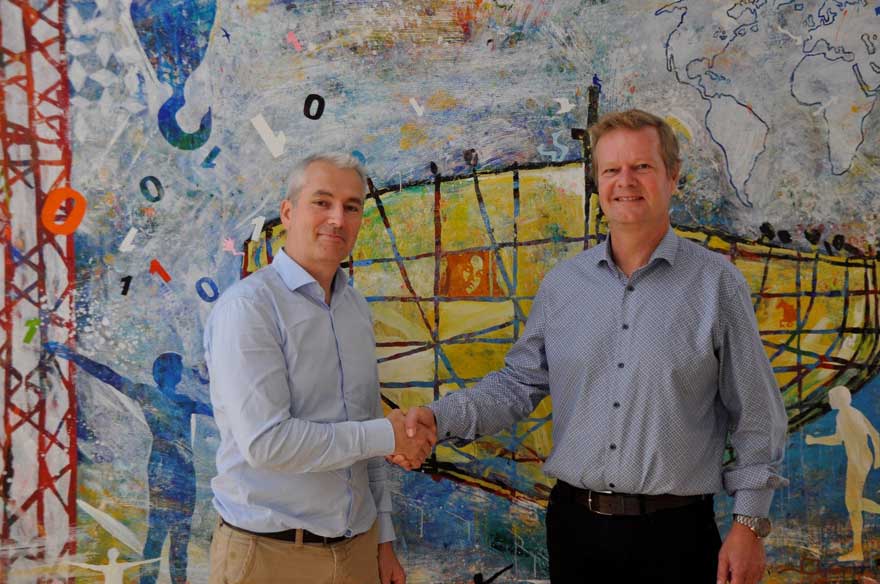 A photo of Lars Riisberg and Emmanuel Lefeuvre shaking hands and smiling at the camera