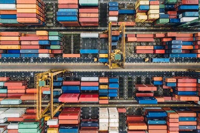 An overhead view of colorful shipping containers stacked in organized rows