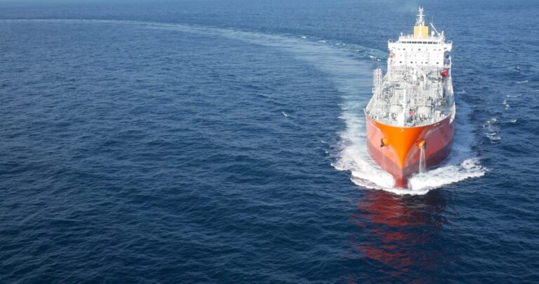 A wide shot capturing the front view of a ship sailing in a half-circle, gracefully entering the picture frame with the vast ocean surrounding it