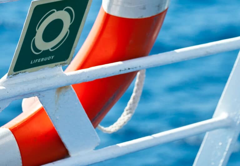 A red and white life ring attached to a ship in compliance with HSQE