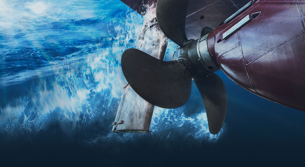 A close-up of a plane's propeller partially submerged in the ocean