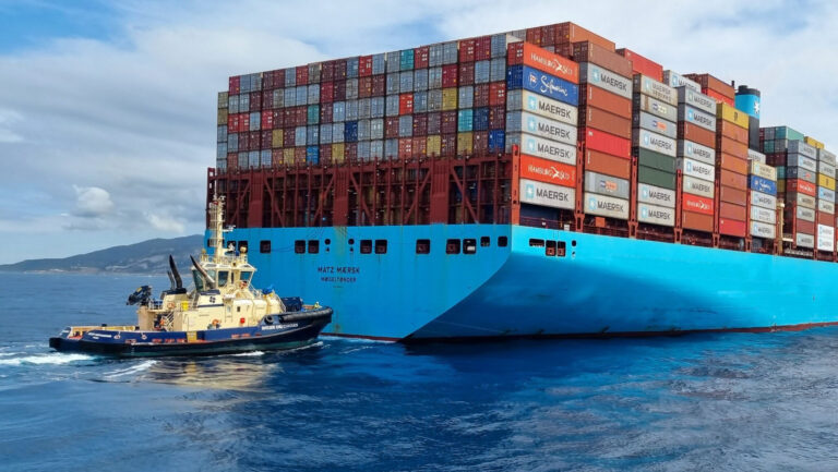 A SVITZER tugboat assisting a MAERSK cargo ship full of containers