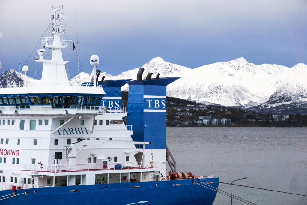 A close-up of the bridge tower on the Tarbit maritime vessel with snowy mountains in the background