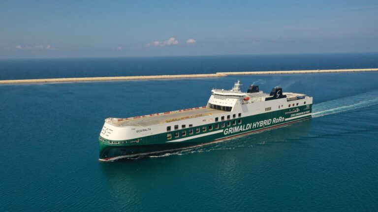 A wide shot from the side of a Grimaldi Hybrid RoRo vessel gliding across a calm sea