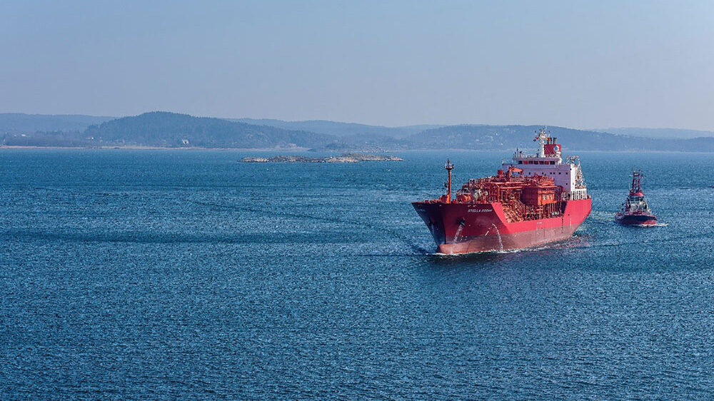A tanker vessel is sailing at sea next to a tugboat