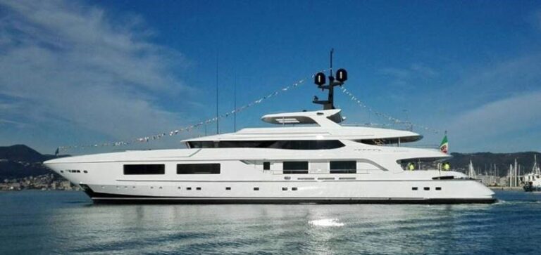 A side view of a luxurious superyacht pulling out of the harbor